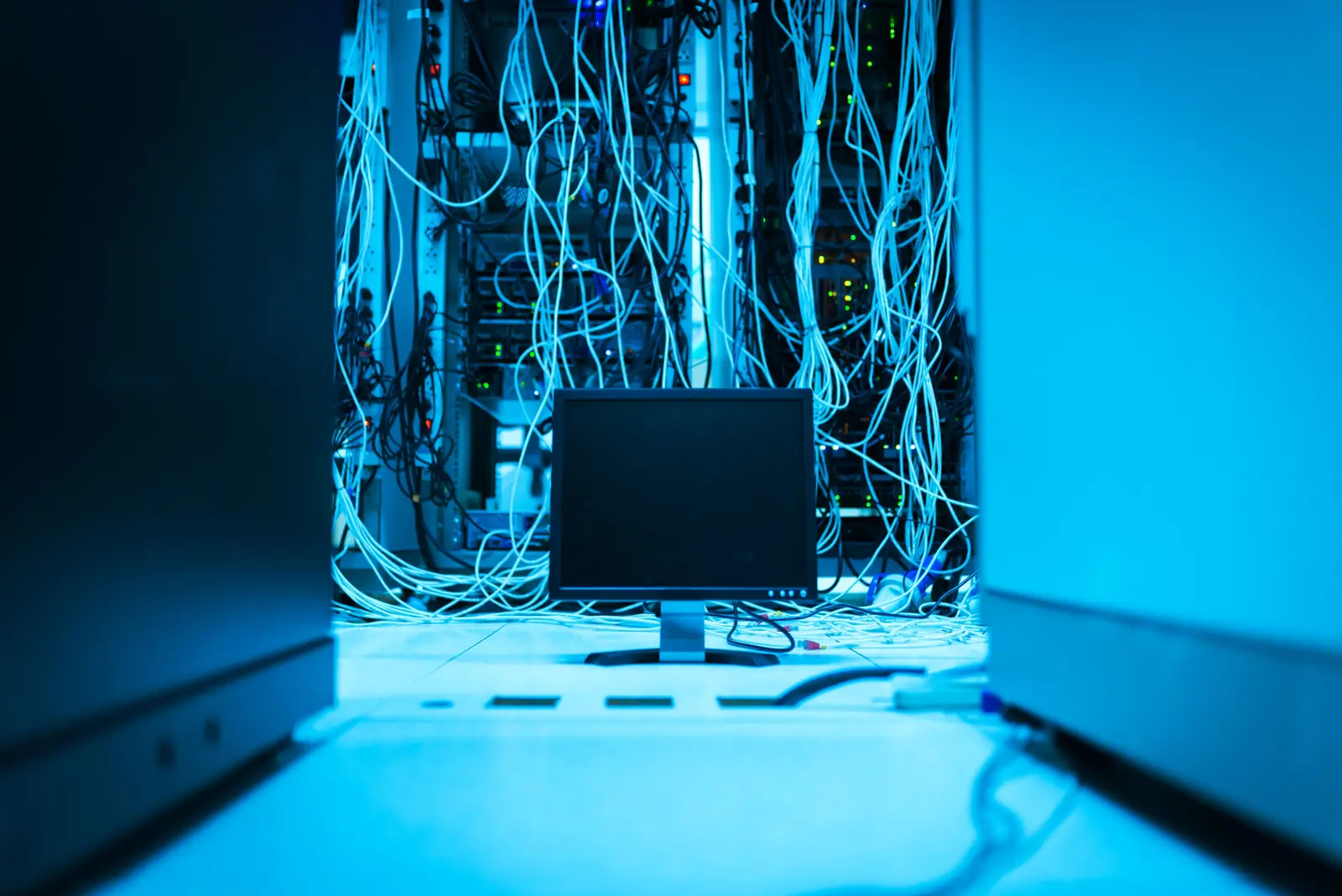 Monitor amplasat lângă cabluri și echipamente de rețea